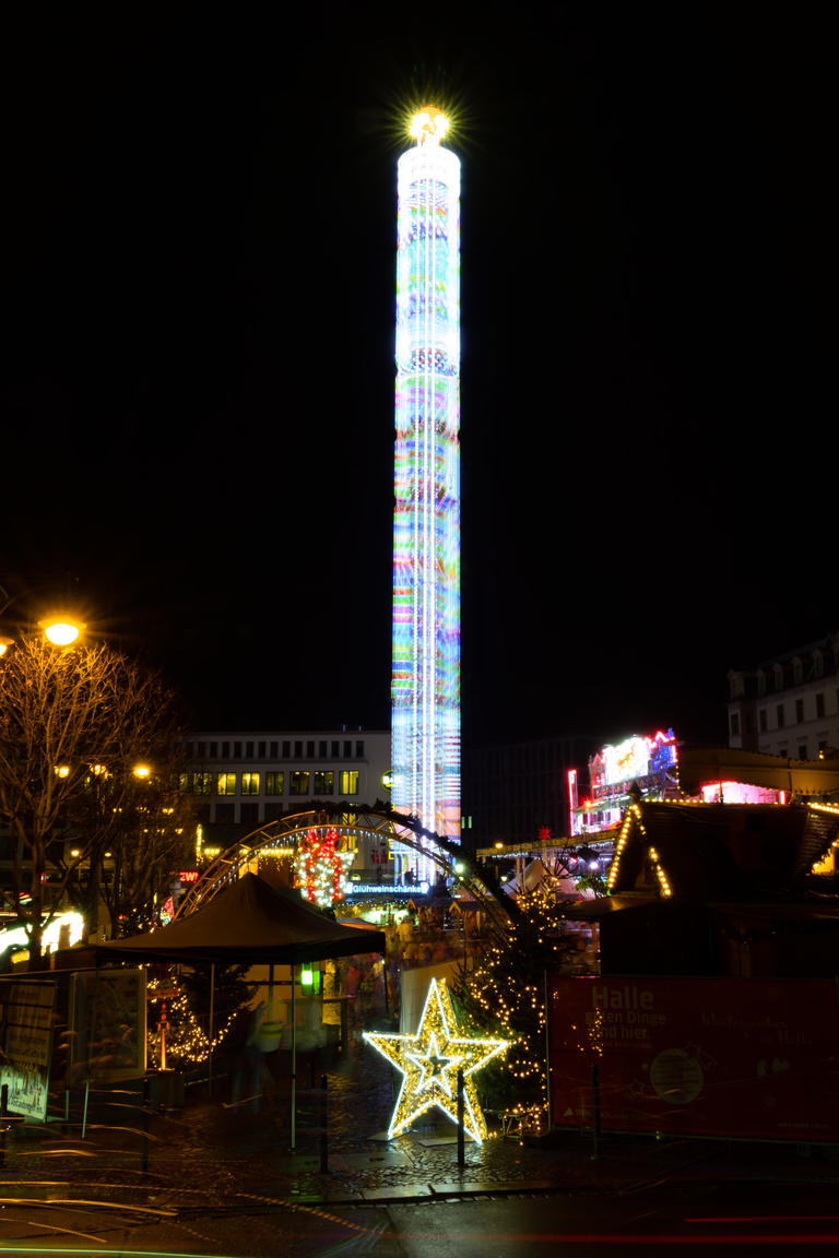 Blick auf den 85m hohen Freefall-Tower am Hallmarkt in Halle. Nachtaufnahme (Langzeitbelichtung) der Gondel-Bewegungen.