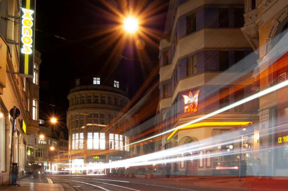 Nachtaufnahme in Halle, Große Ulrichstraße mit vorbeifahrender Straßenbahn